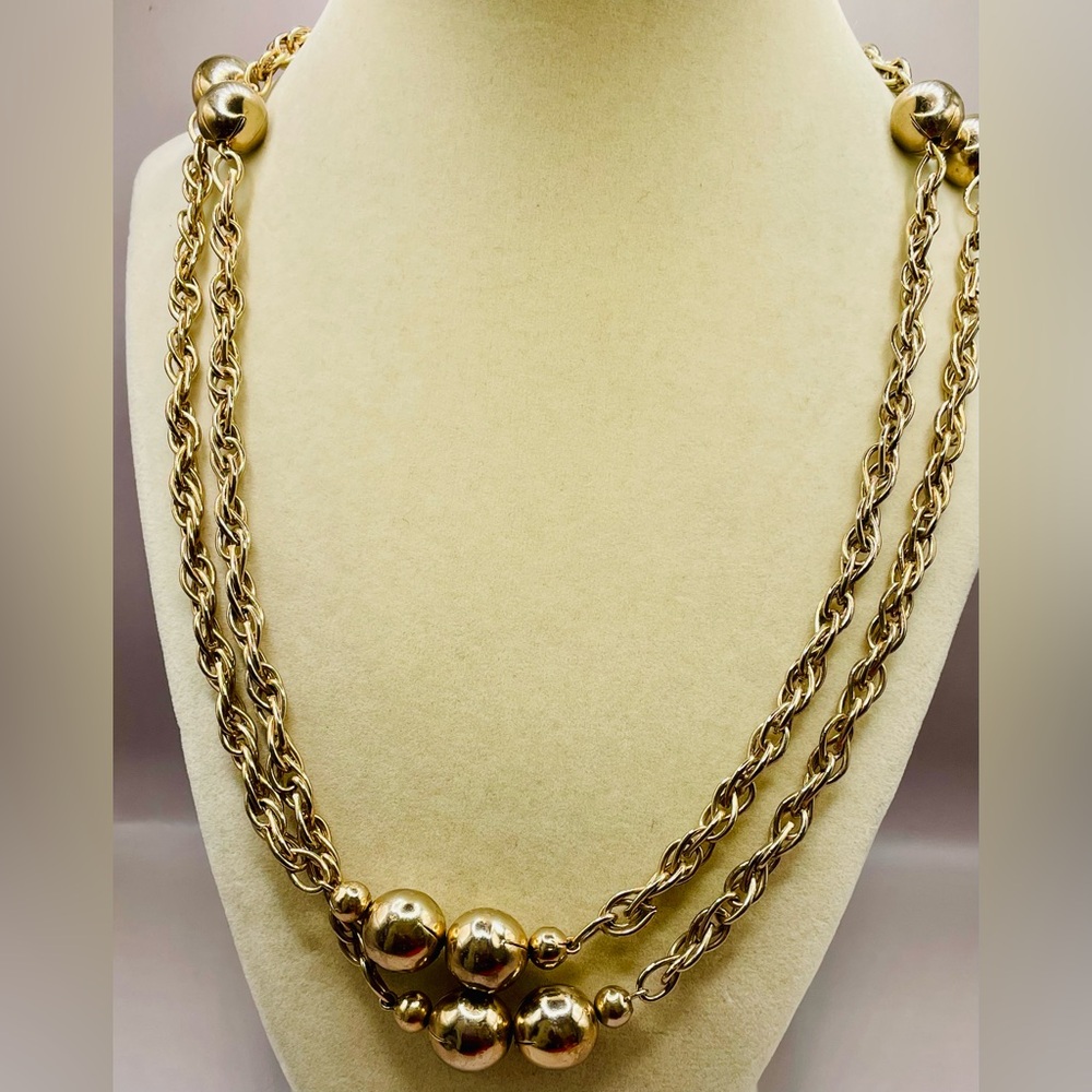 Long pullover gold tone rope chain with large gold bead stations. 56 inches long